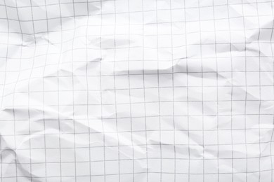 Crumpled checkered notebook sheet as background, top view