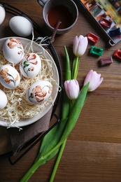 Photo of Flat lay composition with painted Easter eggs on wooden table