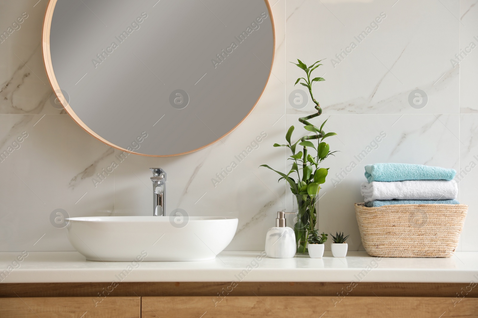 Photo of Beautiful green plants near vessel sink on countertop in bathroom. Interior design elements