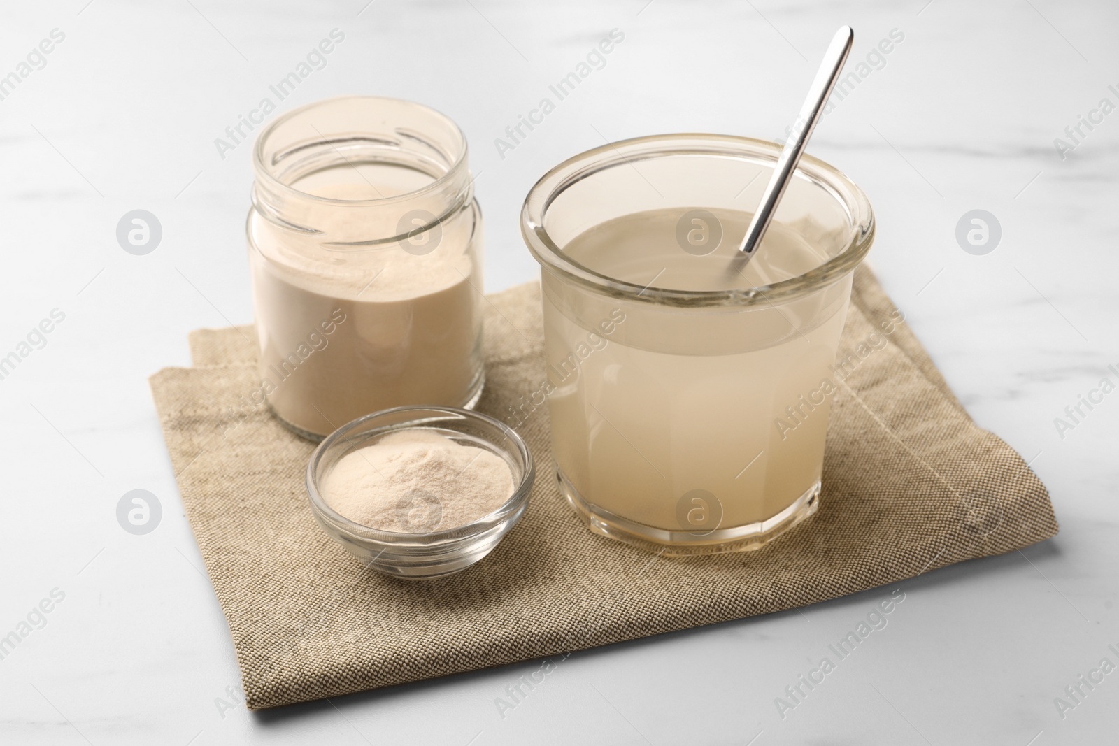 Photo of Agar-agar jelly and powder on white marble table