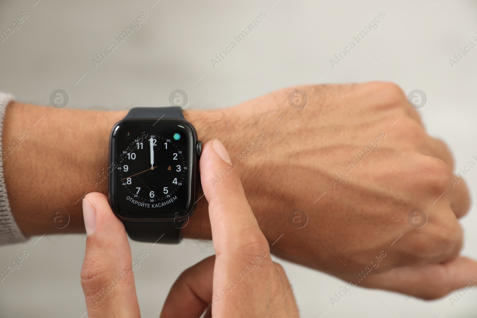 Image of MYKOLAIV, UKRAINE - OCTOBER 04, 2019: Man using Apple Watch to check time on light background, closeup