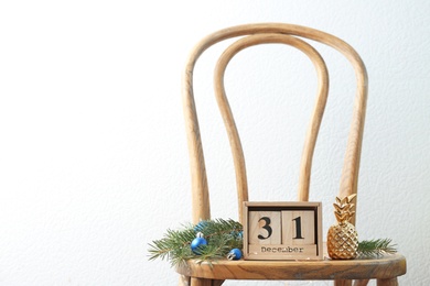 Photo of Wooden block calendar and festive decor on chair. Christmas countdown