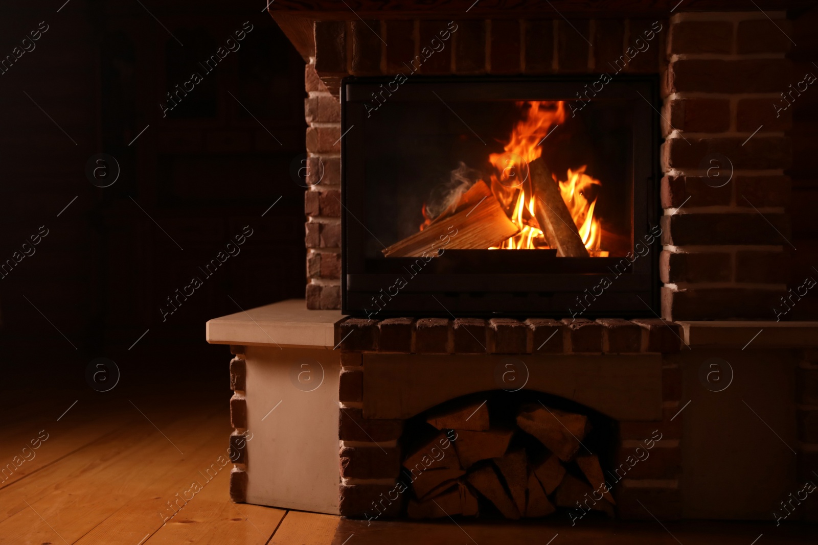 Photo of Fireplace with burning wood indoors. Winter vacation