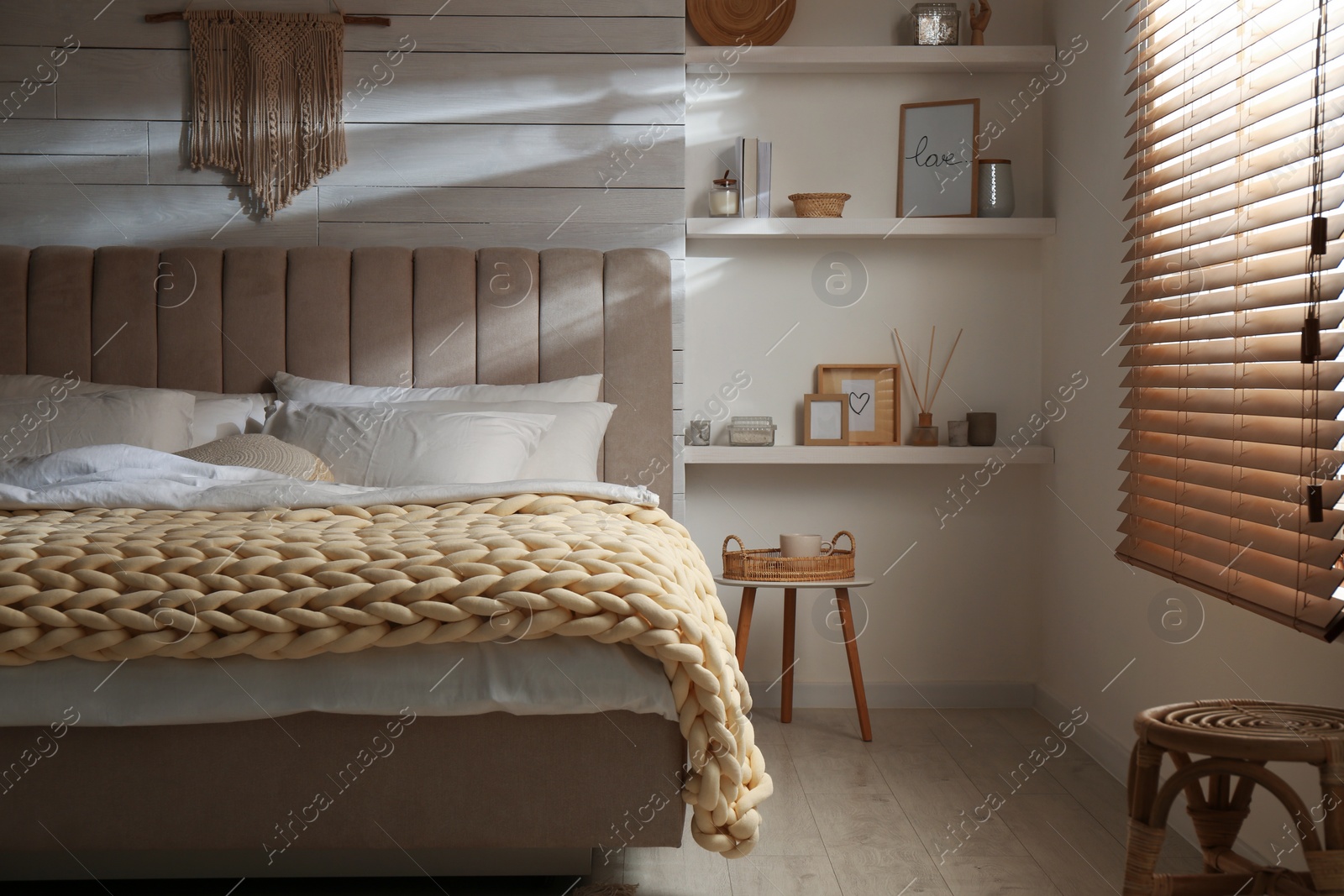 Photo of Soft chunky knit blanket on bed in stylish room