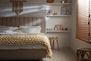 Photo of Soft chunky knit blanket on bed in stylish room