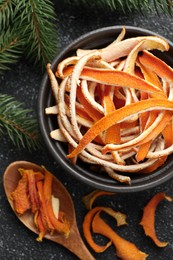 Photo of Dry orange peels and fir branch on gray textured table, flat lay
