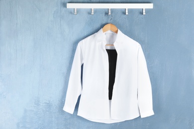 Shirt hanging on blue wall. School uniform