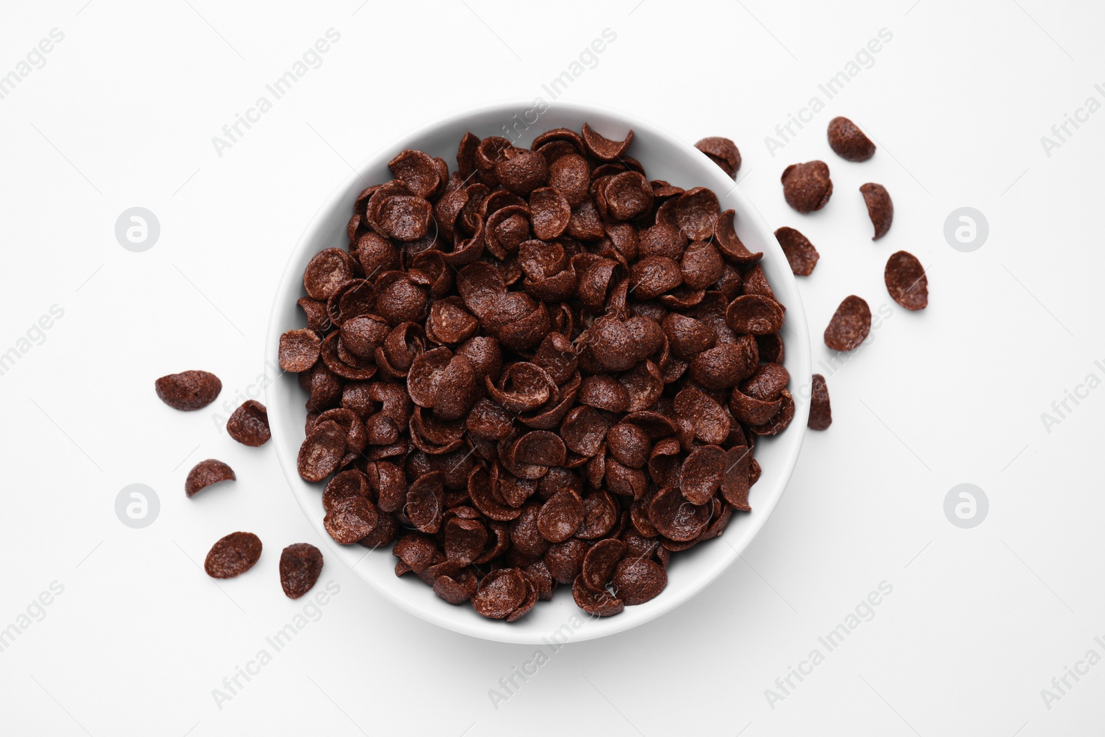 Photo of Breakfast cereal. Chocolate corn flakes in bowl on white table, top view