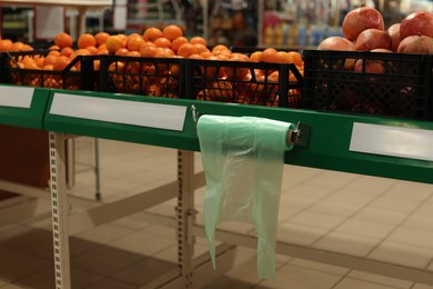 Plastic bags near crates with fruits in supermarket