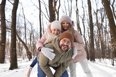 Photo of Happy family spending time together in snowy forest