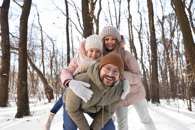 Happy family spending time together in snowy forest