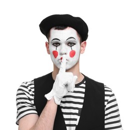 Photo of Mime artist in beret showing hush gesture on white background