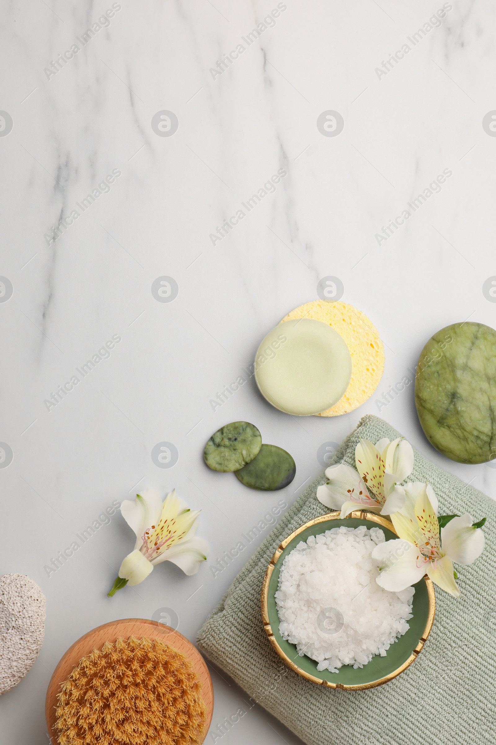 Photo of Flat lay composition with spa products and flowers on white marble table. Space for text