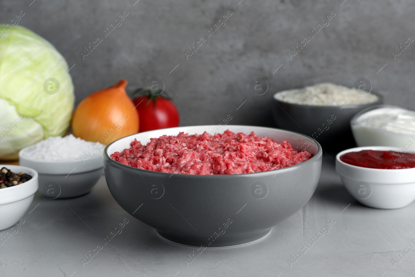 Photo of Set of ingredients for preparing stuffed cabbage rolls on light grey table