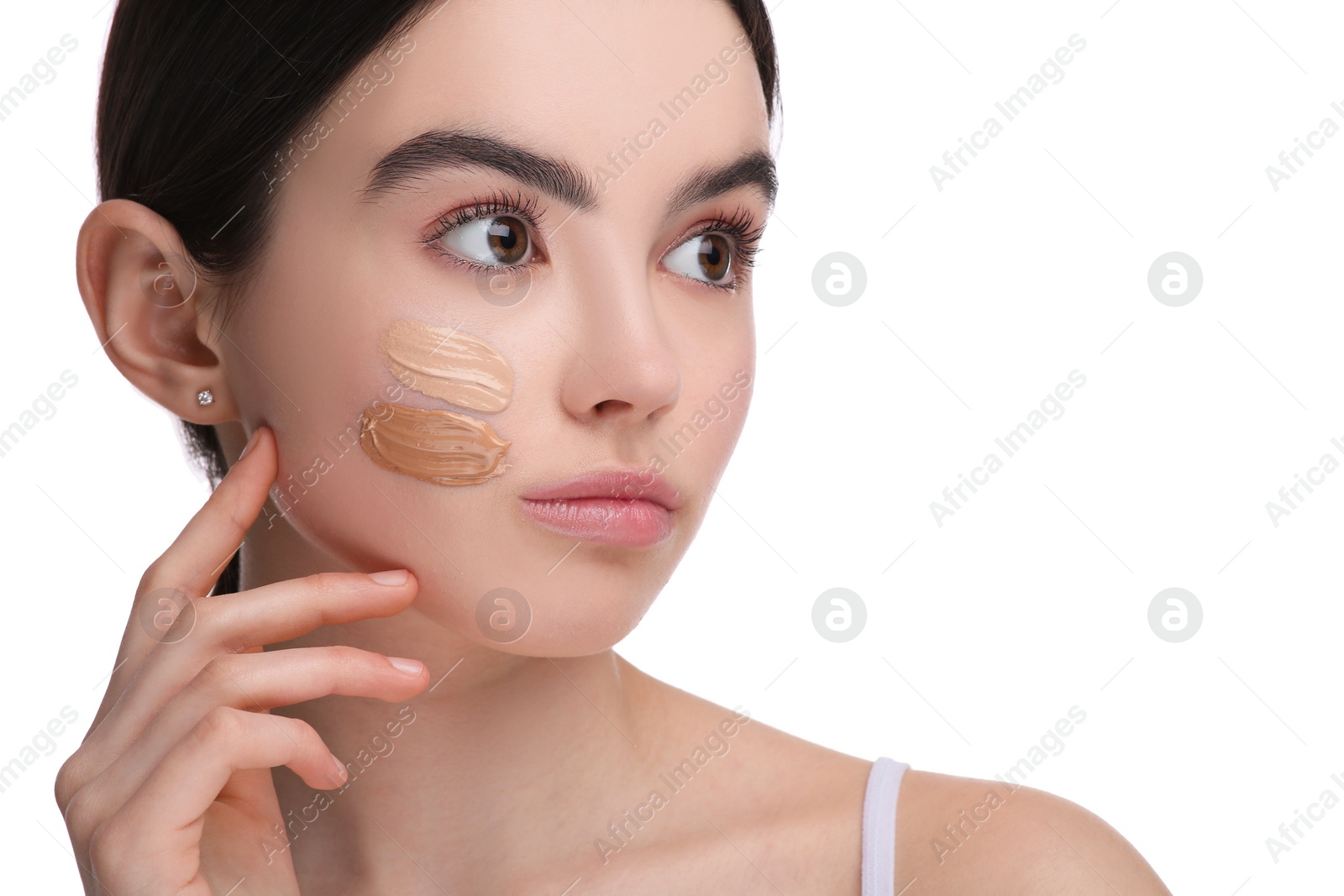 Photo of Teenage girl with swatches of foundation on face against white background