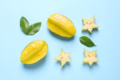 Photo of Delicious carambola fruits on light blue background, flat lay