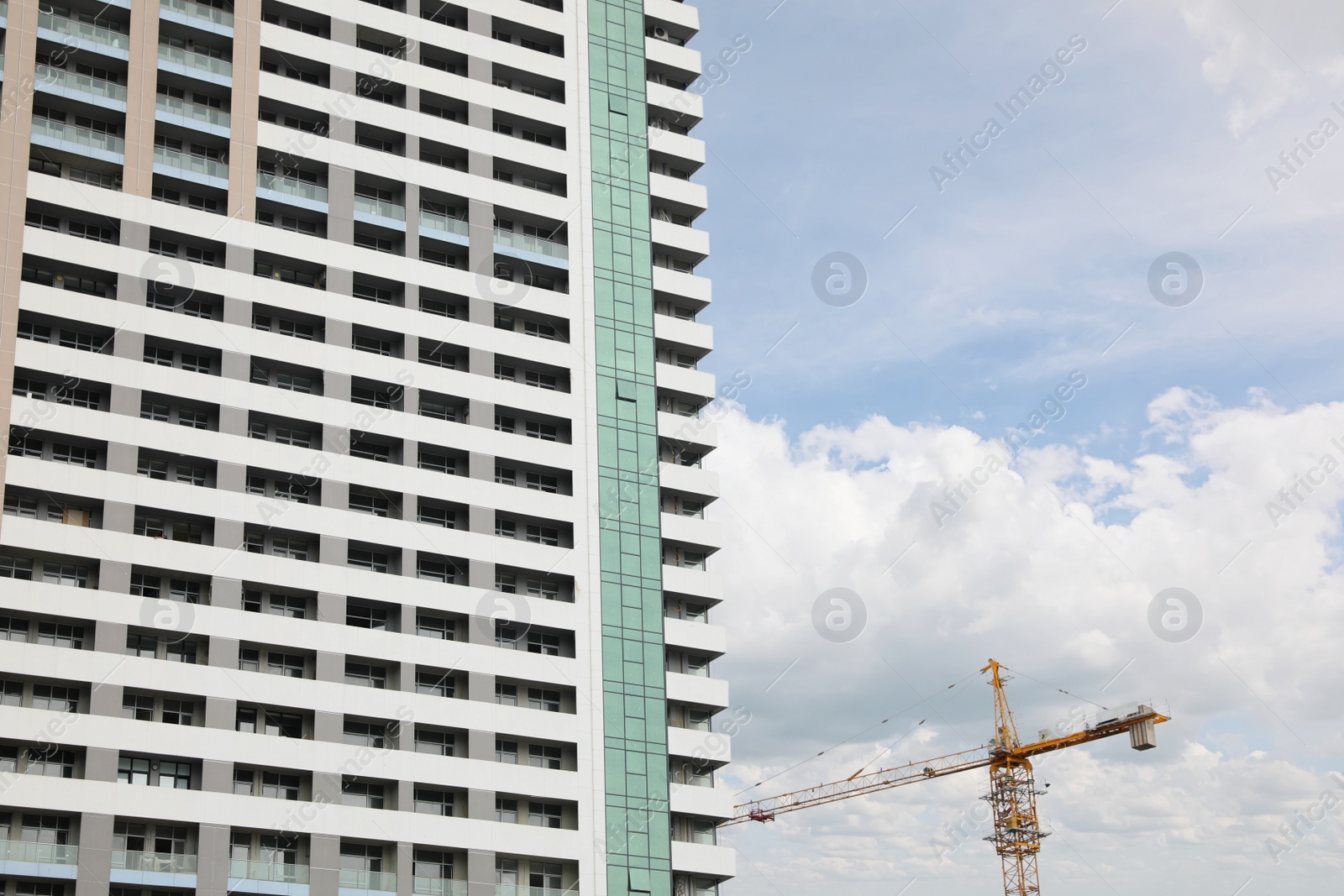 Photo of Construction site with tower crane near unfinished building