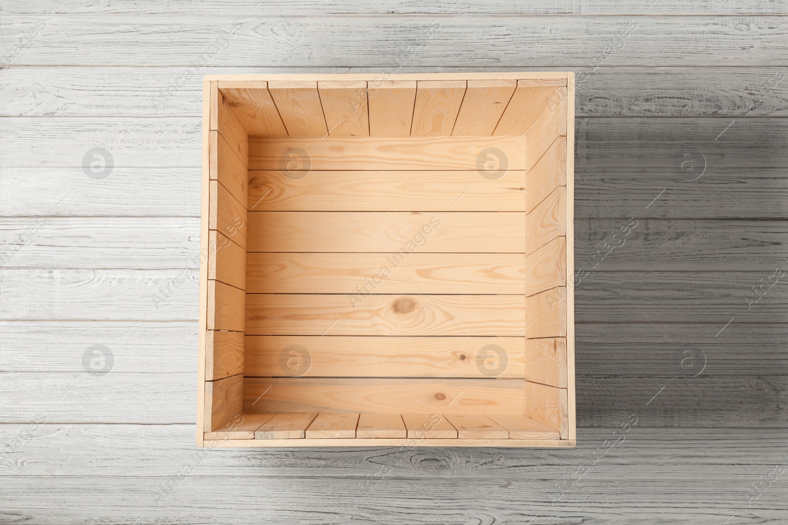 Photo of Open empty wooden crate on light background, top view