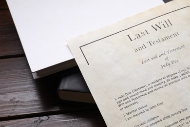 Photo of Last Will and Testament with books on wooden table, closeup