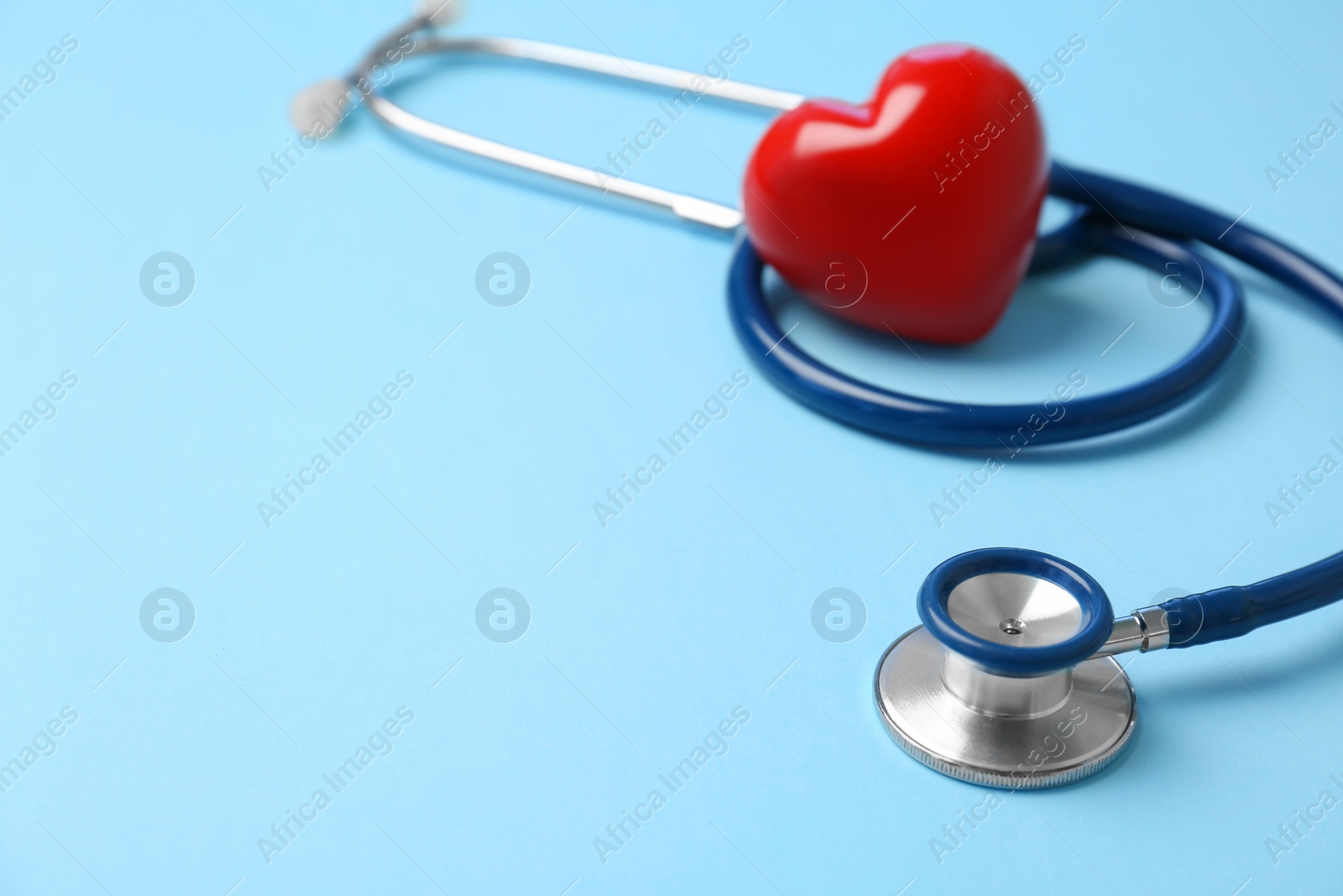 Photo of Stethoscope and heart model on color background. Medical equipment