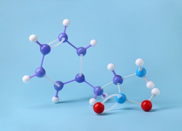 Photo of Molecule of phenylalanine on light blue background. Chemical model