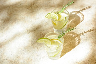 Glasses of tasty refreshing lemonade on light table, space for text. Summer drink