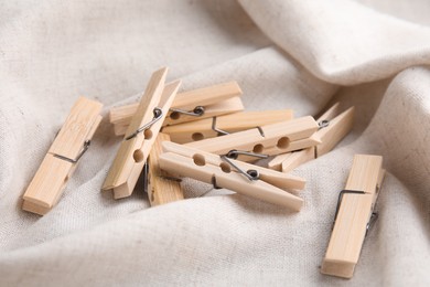 Pile of wooden clothespins on white fabric