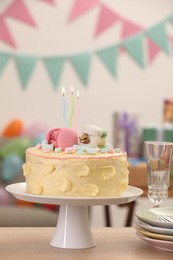 Photo of Delicious cake decorated with macarons and marshmallows on wooden table in festive room. Space for text