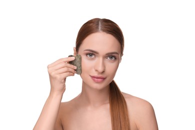 Young woman massaging her face with jade gua sha tool isolated on white