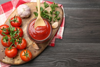 Photo of Tasty ketchup, fresh tomatoes, parsley and spices on grey wooden table, flat lay. Space for text