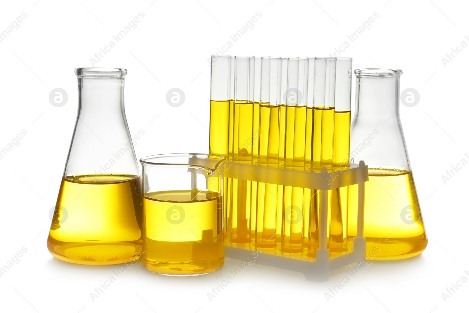 Photo of Laboratory glassware with yellow liquid on white background