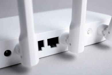 Photo of Wi-Fi router on light grey background, closeup