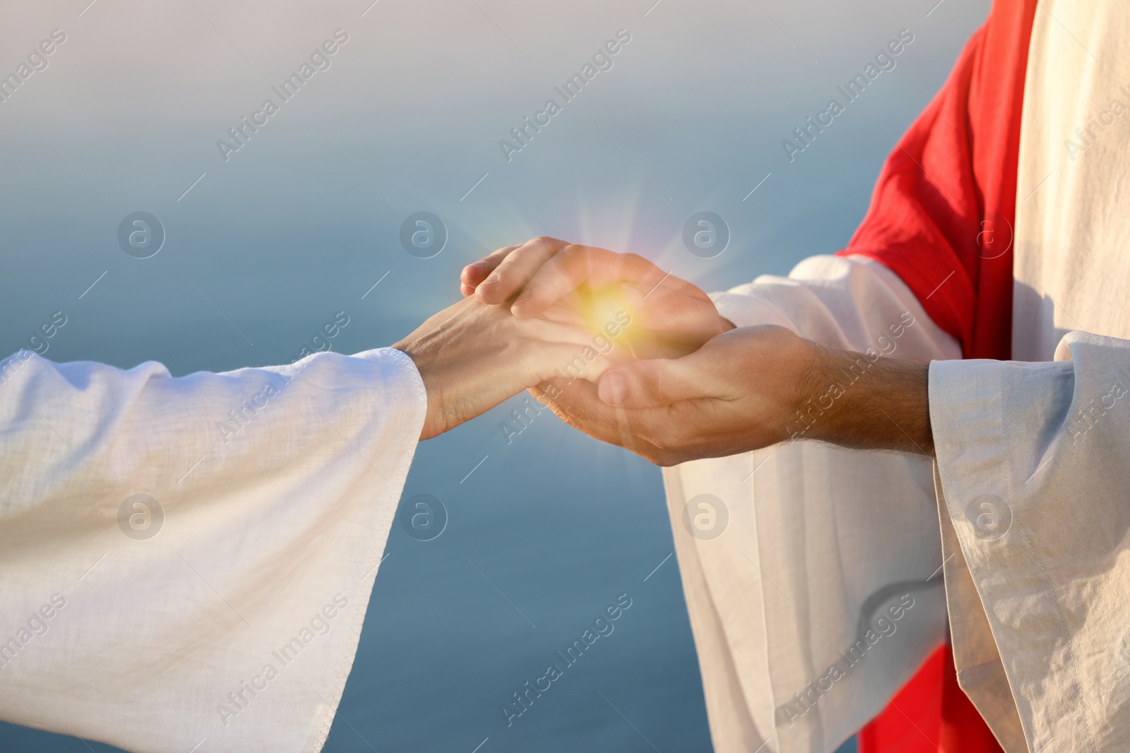 Image of Jesus Christ and woman near water outdoors, closeup. Miraculous light in hands