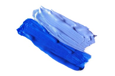 Photo of Samples of blue paint on white background, top view