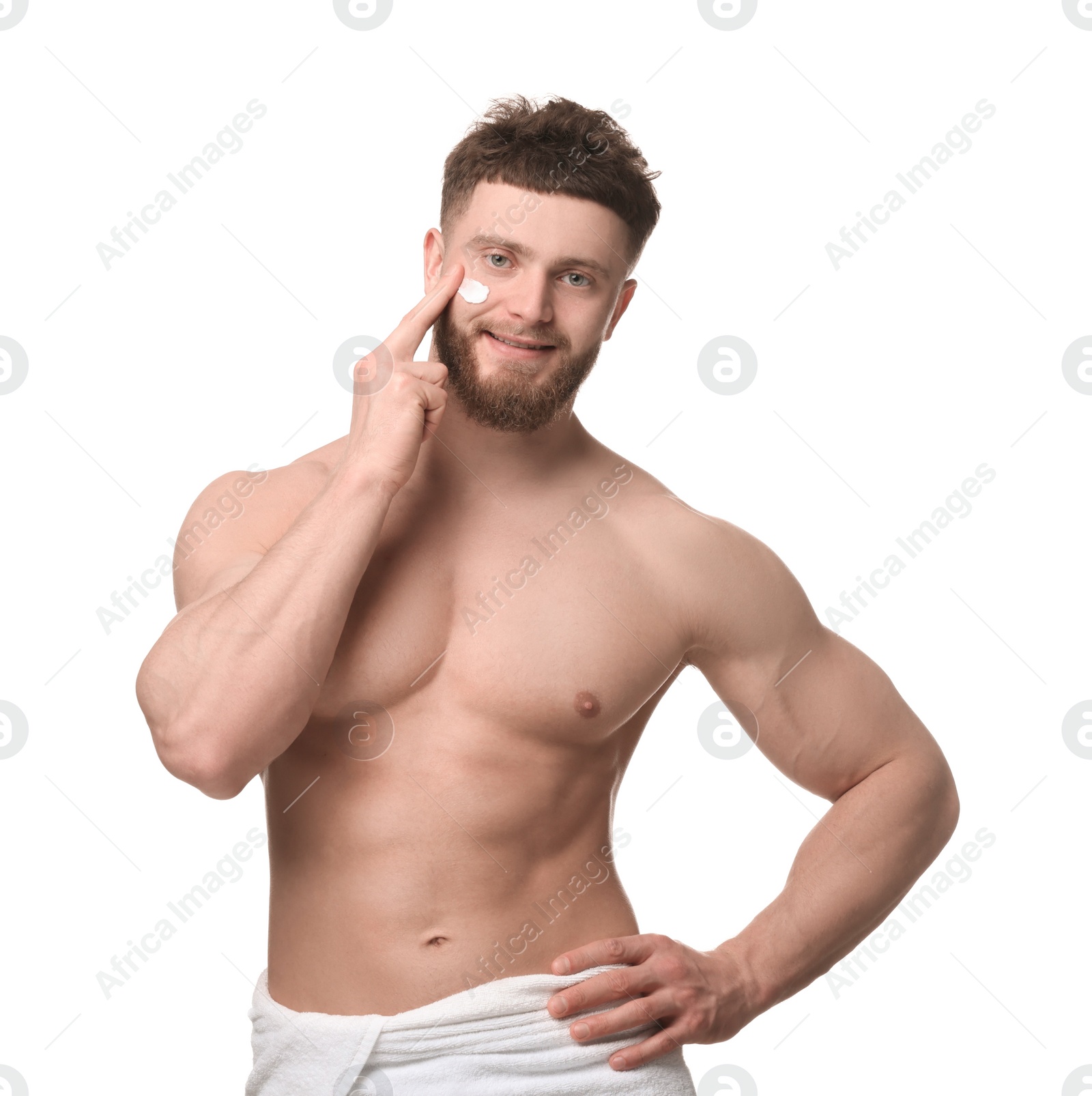 Photo of Handsome man applying moisturizing cream onto his face on white background