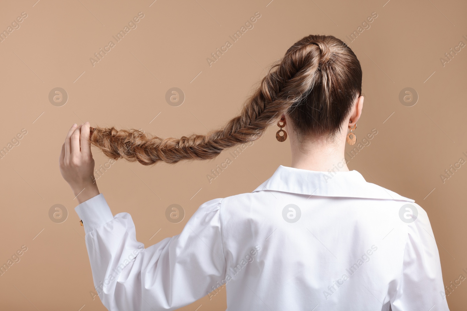 Photo of Woman with braided hair on brown background, back view