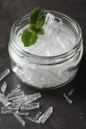 Photo of Menthol crystals and mint leaves on grey background