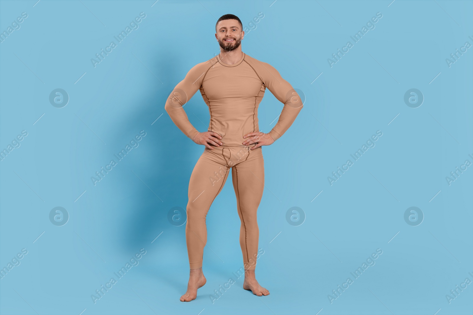 Photo of Man in warm thermal underwear on light blue background. Space for text