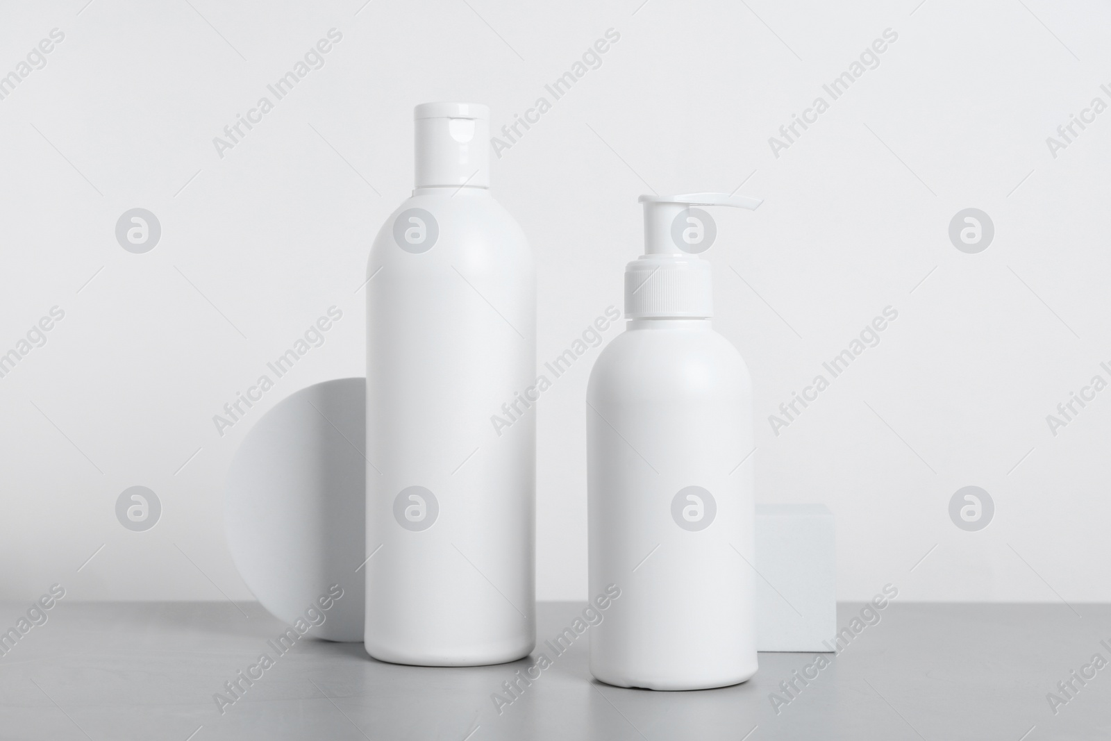 Photo of Bottles of cosmetic products on grey table