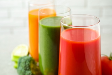 Photo of Different tasty juices in glasses, closeup. Space for text