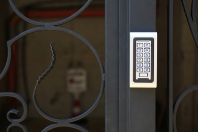 Modern intercom system on black metal gates, space for text. House security