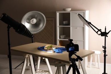 Professional camera on tripod and composition with tasty sandwich in photo studio. Food photography