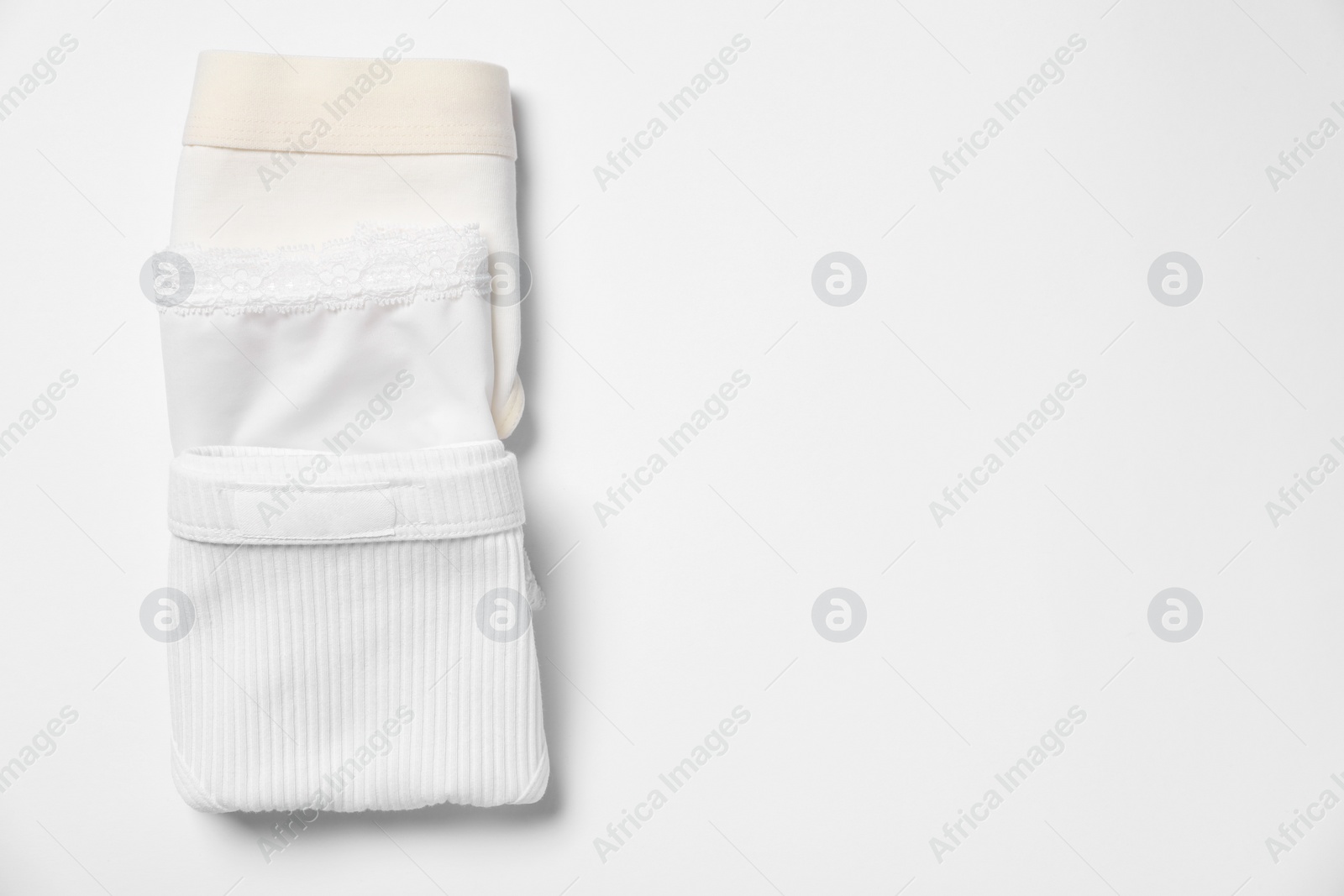 Photo of Stylish folded women's underwear on white background, flat lay. Space for text