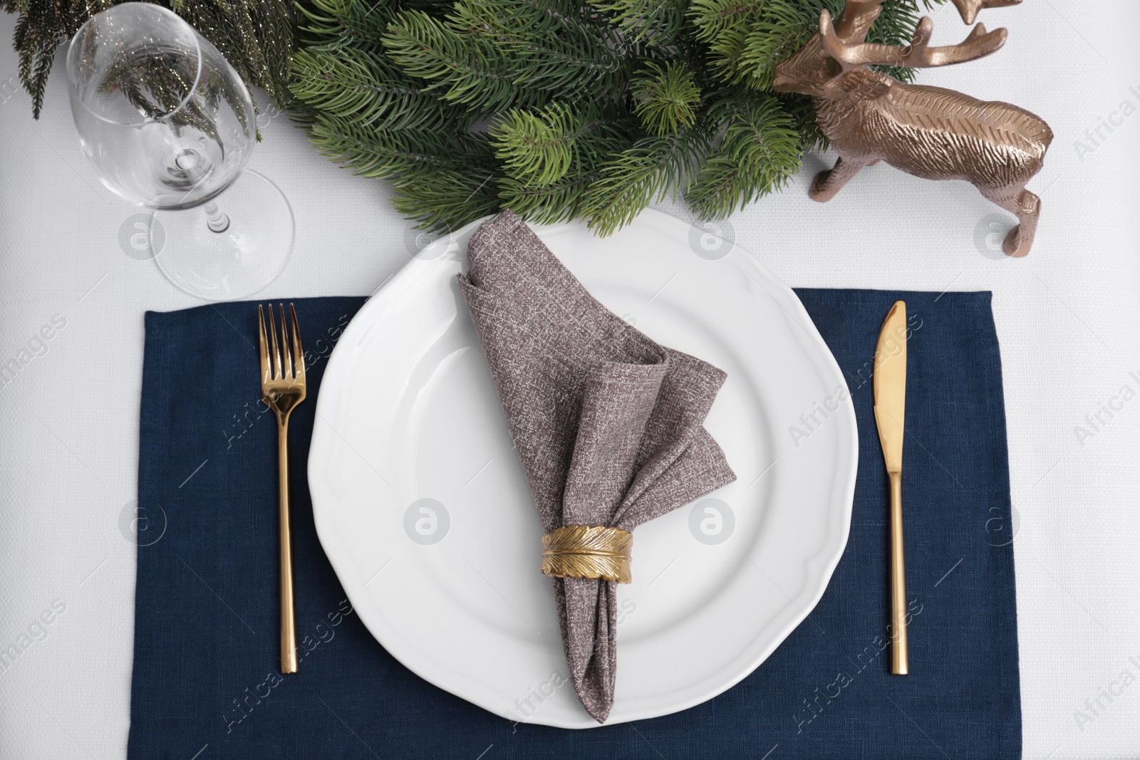 Photo of Festive place setting with beautiful dishware, cutlery and fabric napkin for Christmas dinner on white table, flat lay