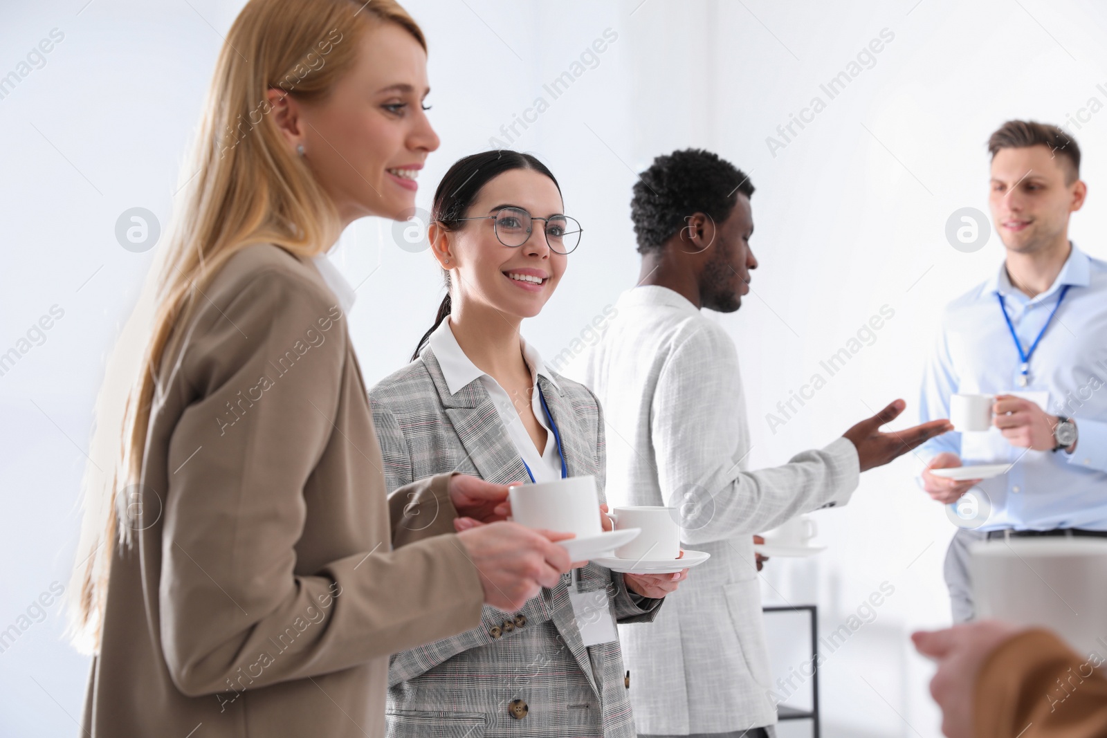 Photo of Group of people chatting during coffee break indoors