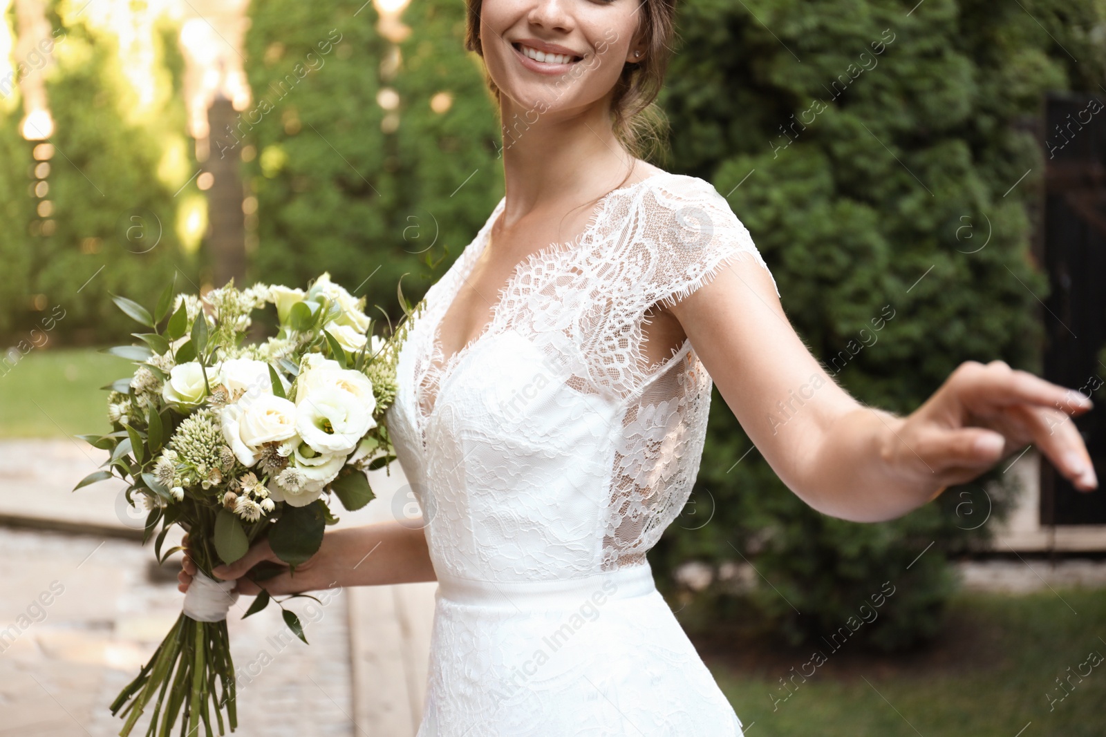 Photo of Bride in beautiful wedding dress with bouquet outdoors, closeup