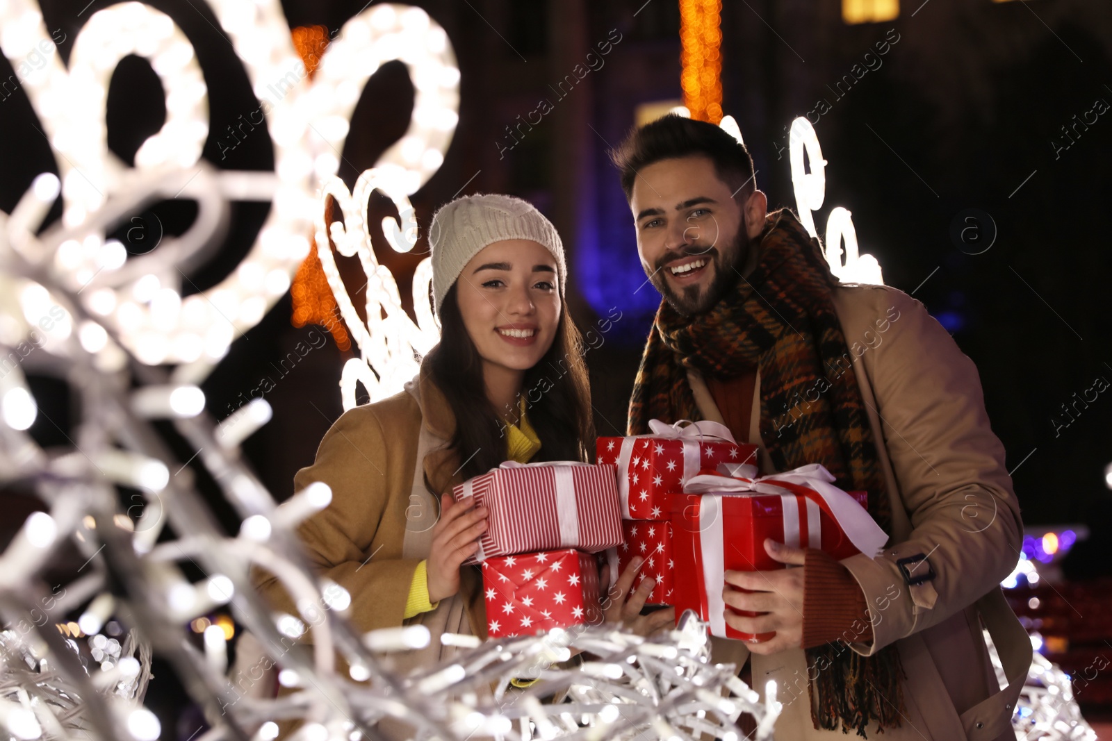 Photo of Lovely couple with Christmas presents at winter fair