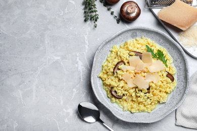 Photo of Delicious risotto with cheese and mushrooms on grey marble table, flat lay. Space for text