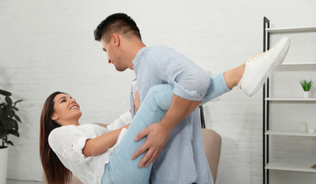 Happy couple dancing in living room at home