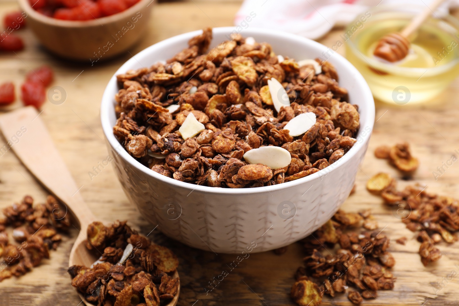 Photo of Tasty granola served with nuts and dry fruits on wooden table